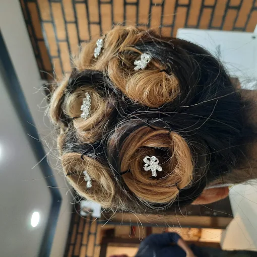 Bun updo hairstyle finished with crystal hair pins by the salon team